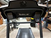 Overall treadmill showing the SOLE branding on front bottom frame, running belt, and part of the basement storage background.