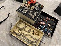 Photo showing all contents of three boxes of vintage jewellery and watch including pins, brooches, earrings, necklaces and bracelets