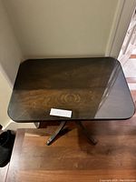 Top view of the rectangular wooden table with glass top showing wood grain and minor small spots on surface