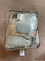 Packaged king-sized light blue 3-piece bedspread set, unopened with clear carrying case and visible quilted medallion pattern on bedspread and pillow shams.