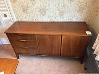 Full front view of sideboard showing overall shape, drawer section, and cabinet doors