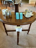 Full view of all six sets of salt and pepper shakers and one pepper mill arranged on a wooden table.