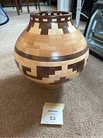 Front view of segmented wooden bowl showing intricate geometric patterns and wood color variations.