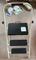 Front view of Skinny Mini step stool showing three black ribbed steps and handle bar.