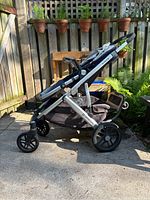 Side view of blue and silver UPPAbaby Vista stroller showing frame, wheels, and storage basket.
