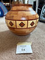 Front view of the round wooden segmented bowl showing the geometric pattern band with diamond shapes and overall wood grain.