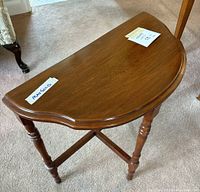Top view of semi-circular wooden side table showing smooth wood grain.
