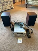 Yamaha stereo receiver set including the receiver, remote, and pair of Paradigm bookshelf speakers placed on carpet.