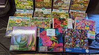 Photo showing multiple 300-piece puzzles including BRIGHTS floral designs and Pixar puzzle with characters