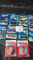 Overview photo of 10 Hot Wheels cars with various designs including Treasure Hunt and limited edition, plus two baseball player buttons featuring MLB players.