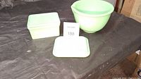 Overview photo showing the 6-inch jadeite bowl, the covered rectangular dish, and the spare lid all placed on a surface.