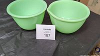 Two light green Jadeite mixing bowls placed side by side showing both rounded rims, one with a pour spout.