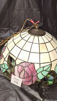 Photo showing the pendant light dome with pink rose design and hardware chain.