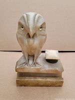Front view of the carved stone owl inkwell, showing owl figure and inkwell with lid on rectangular base.