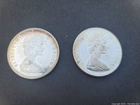 Two 1965 Canadian silver dollar coins, obverse side showing Queen Elizabeth II.