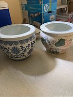 Both large ceramic garden pots shown side by side, highlighting size and decorative styles.