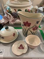 Handmade pottery set showing a tall vase, small bowl, small plate, and butter dish with floral and butterfly decor.