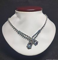 Full view of vintage Continental necklace on display bust showing double strands of rhinestones and three dangling clusters.