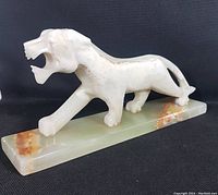 Full view of white onyx tiger sculpture on rectangular onyx base, highlighting tiger's full body and natural veining.