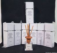 Full set of seven fragrance diffuser boxes, each labeled with day and scent, with one diffuser bottle and reeds in front.