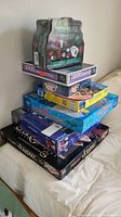 Stack of puzzles and games showing multi-box set with poker game on top