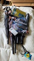 Photo showing 4 umbrellas and packaged multi-tool sitting on bed