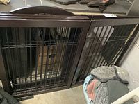 Wood dog crate folded, showing scuffed wood and metal bar sides