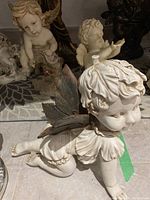 Angel figurine with butterfly wings crawling on floor, detailed face and wings