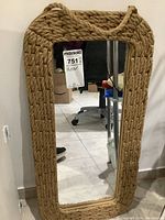 Front view of a rectangular mirror with a thick woven rope frame and a natural tan color.