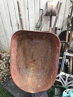 Top view showing the rusty metal tray of the wheelbarrow.