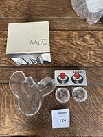 Top view image showing the Aalto vase, original Aalto box, two Iittala Maaru candle holders, and original box for candle holders with two red candles inside.