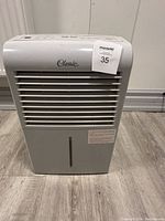 Front view of Classic dehumidifier with vented grille, water level window, and sticker