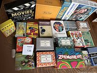 Photo showing the full collection of boxed games with titles visible including Night at the Movies Trivia, Zobmondo, Pictionary, and several games from The Games Room series.
