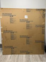 Front side of acrylic Plexiglas sheet with original protective paper intact, showing printed brand and care instructions.