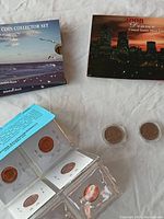 Collector coins displayed on surface including packaged sets and individual coins