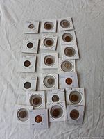 Collection of around 20 vintage US coins, each in individual holders with annotations visible about the coin's year and mint mark.