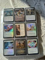 Nine Magic The Gathering cards in sleeve, showing various creatures and spells laid out in a plastic page.