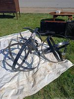 Photo showing all three metal orb pendant light fixtures placed on a white tarp outdoors.