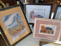 Photo showing three picture frames with cityscape and architectural artwork, including Big Ben and a building entrance with autumn leaves.