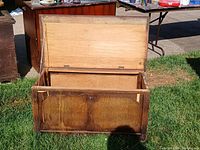 Open large vintage wooden storage chest showing interior and front panel design