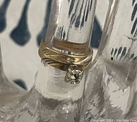 Front view of the 14k gold engagement ring with prong setting showing removed stone paired with a gold band