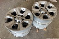 Four stacked 17-inch Toyota alloy wheels with 6-spoke design inside garage setting.