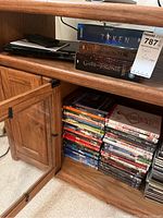 Photo showing an open cabinet with multiple DVDs stacked, including Alvin and the Chipmunks and other assorted movies.