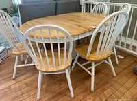 Overview of oval table, four chairs and bench