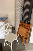 White wooden side chair with vertical slat backrest and seat shown from multiple angles.