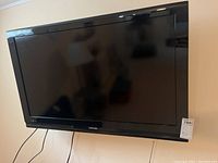 Front view of Toshiba 46-inch TV mounted on the wall, showing the entire screen and part of the wall.