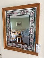 Front view of rectangular mirror with wooden frame and stained glass floral border