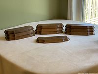 Ten wooden figurine boosters arranged on a table showing their shape and size relative to one another.