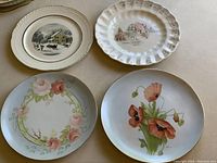Overview of four decorative plates showing detailed floral designs and winter scene.