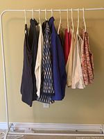 Clothes hung on a rack including tops, jackets, shorts and pants in size 3X/22, arranged by type and color.